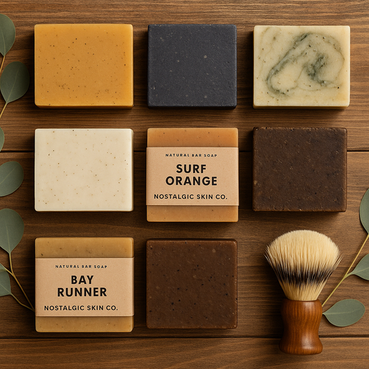 Nostalgic Skin Co. natural men’s soaps—Surf Orange and Bay Runner—on rustic wood with eucalyptus and a shaving brush.