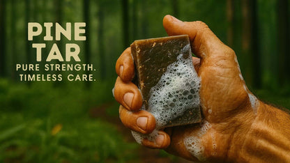 Close-up of a hand holding Pine Tar soap, lathering with bubbles in a forest setting.