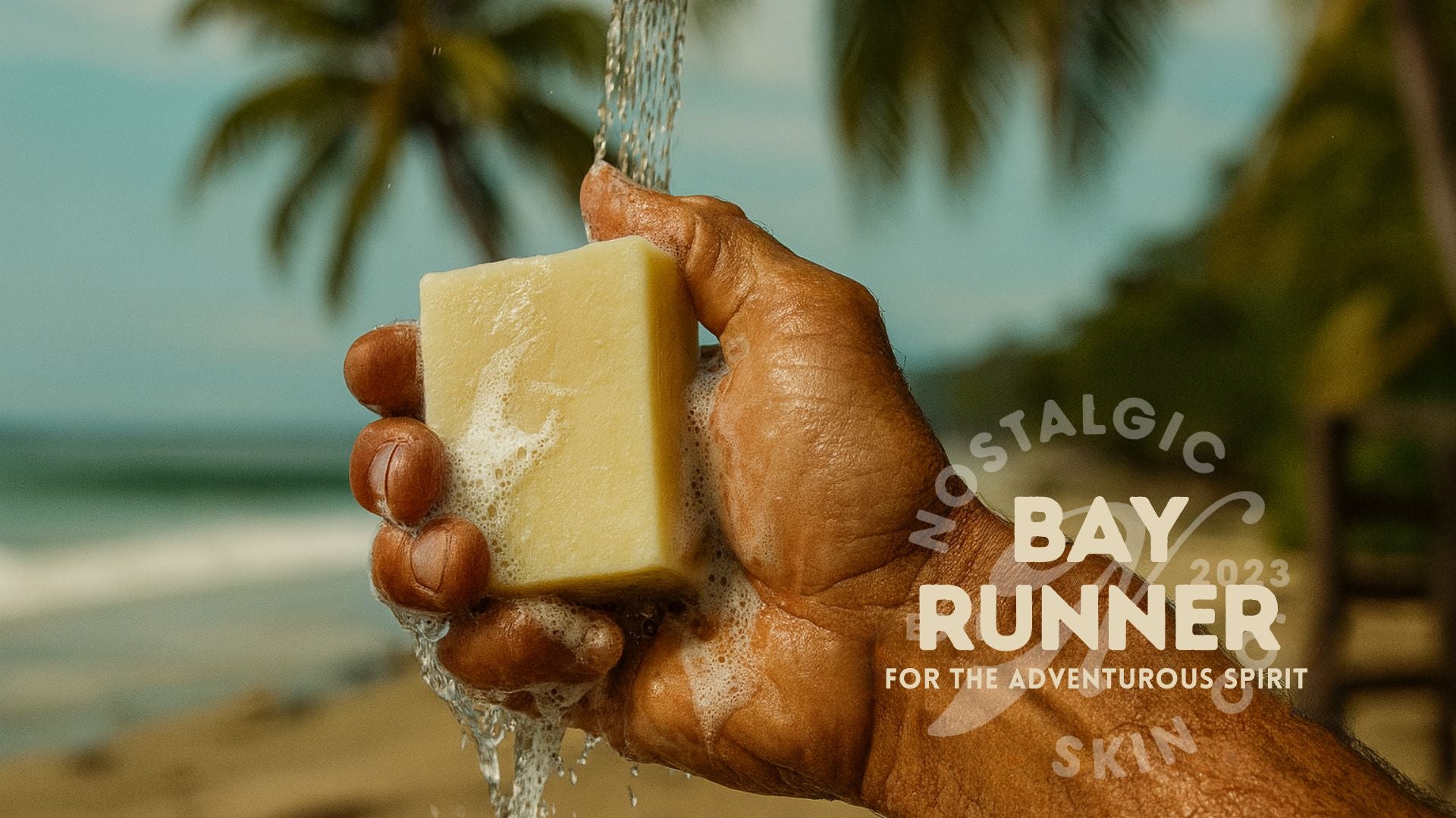 Hand holding Bay Runner Soap under a waterfall, evoking a refreshing ocean breeze and bold citrus aroma.