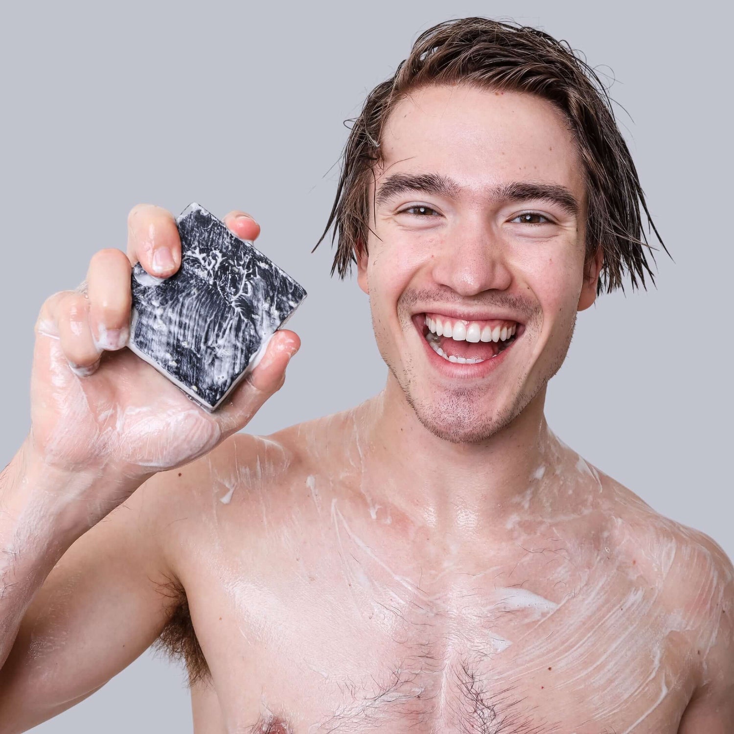 Man holding Campfire Bar Soap with suds lathered on his hands, highlighting its rich, foamy texture and rugged appeal by Nostalgic Skin Co.