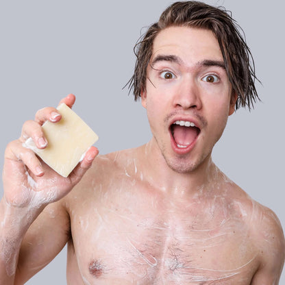 Excited man holding Bay Runner Men's Bar Soap, showcasing its natural freshness and creamy lather for a refreshing shower experience.