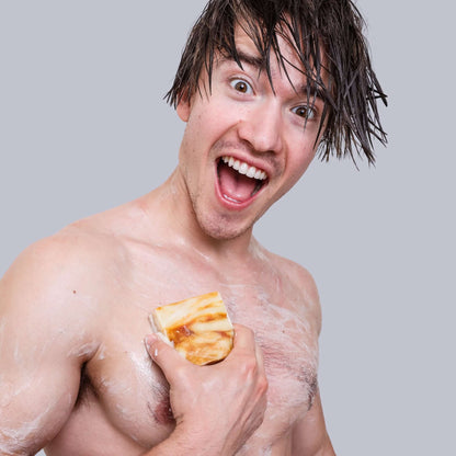 Energetic man enjoying Surf Orange Men's Bar Soap, showcasing its refreshing citrus scent and nourishing ingredients.