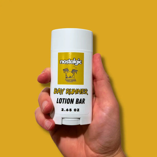 Bay Runner Lotion Bar held in hand, showcasing its organic ingredients and convenient lotion stick design.